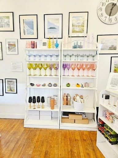 White shelves with colorful glassware, mugs and giftware