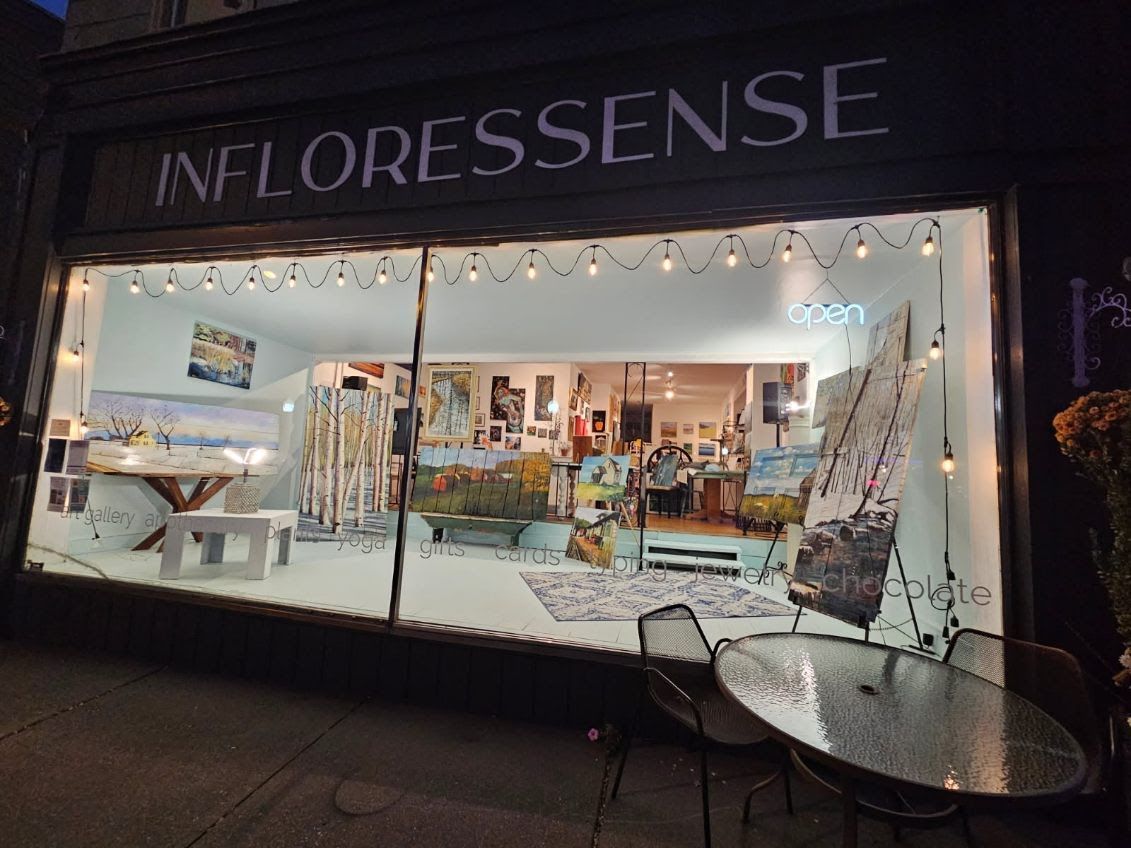 Infloressense storefront at night on Water Street, with gallery lights glowing through the front window